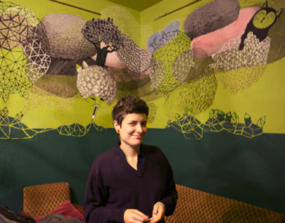 Photo of Joaquina in front of a self-made wall painting.